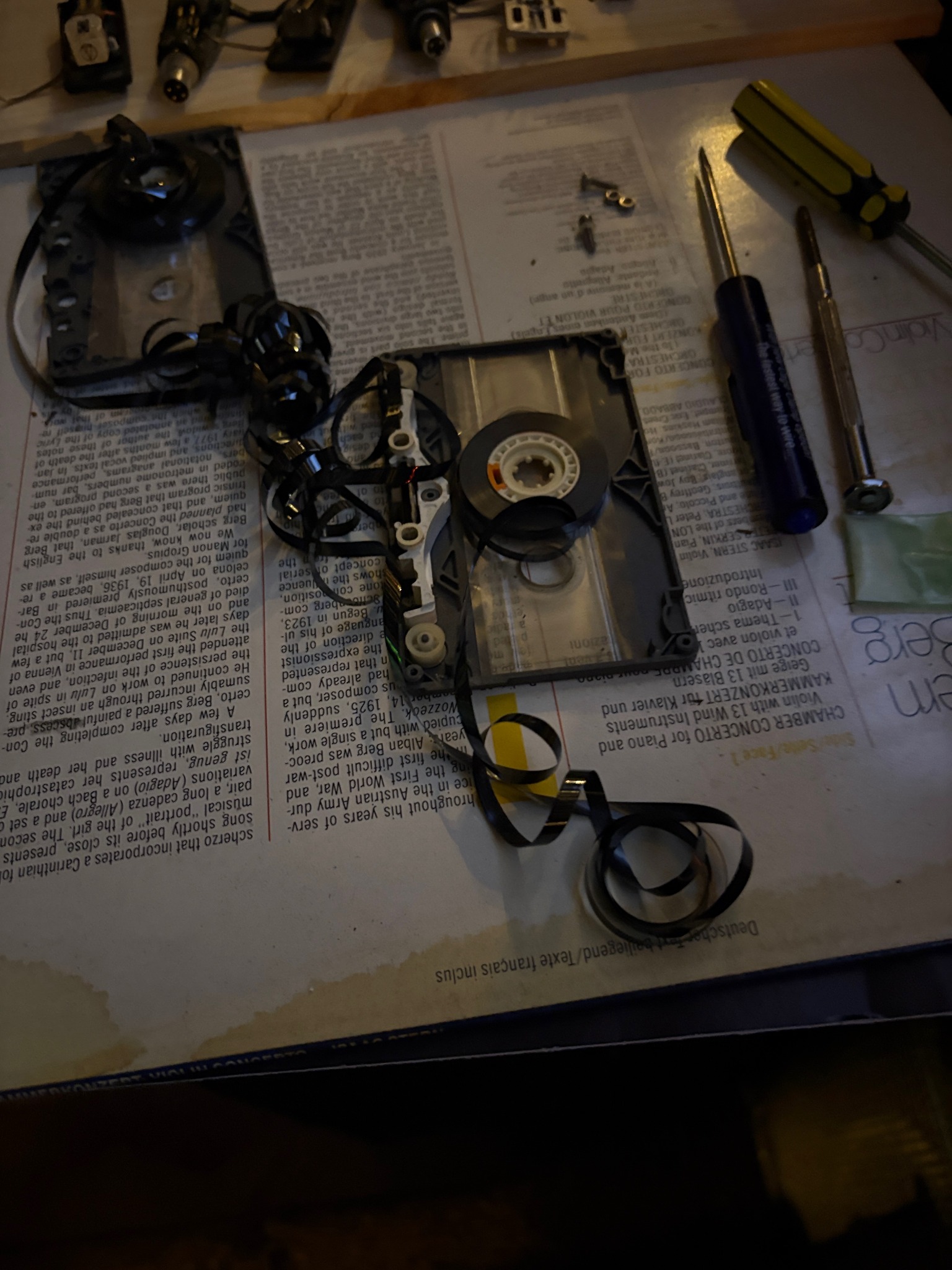A dismantled cassette with its magnetic tape exposed